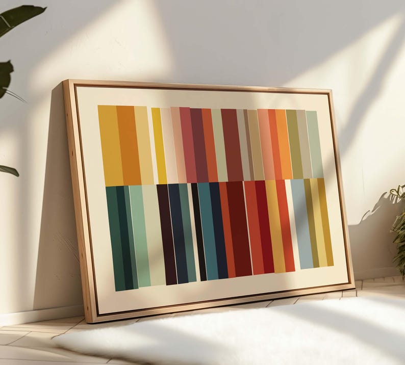 Puede incluir: Una impresi&oacute;n art&iacute;stica abstracta enmarcada con rayas verticales multicolores. La paleta de colores incluye amarillo, naranja, rojo, azul y verde. La obra de arte est&aacute; enmarcada en un marco de madera clara, contra una pared blanca.