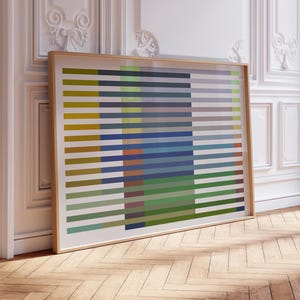 May include: A rectangular framed wall art piece featuring a series of horizontal stripes in various colors including mustard yellow, olive green, navy blue, and light gray, layered over a central vertical block of solid blue and green tones.