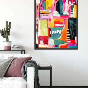 May include: Abstract painting with bold, colorful shapes and lines in shades of pink, yellow, orange, green, blue, and black. The painting is framed in a black frame.
