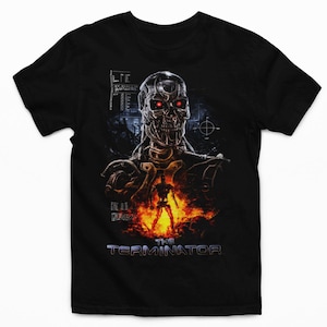 May include: A black short-sleeve t-shirt featuring a graphic print of a metallic cyborg skull with glowing red eyes. Below the skull, a small full-body cyborg figure stands amidst orange flames. The text THE TERMINATOR appears at the bottom.