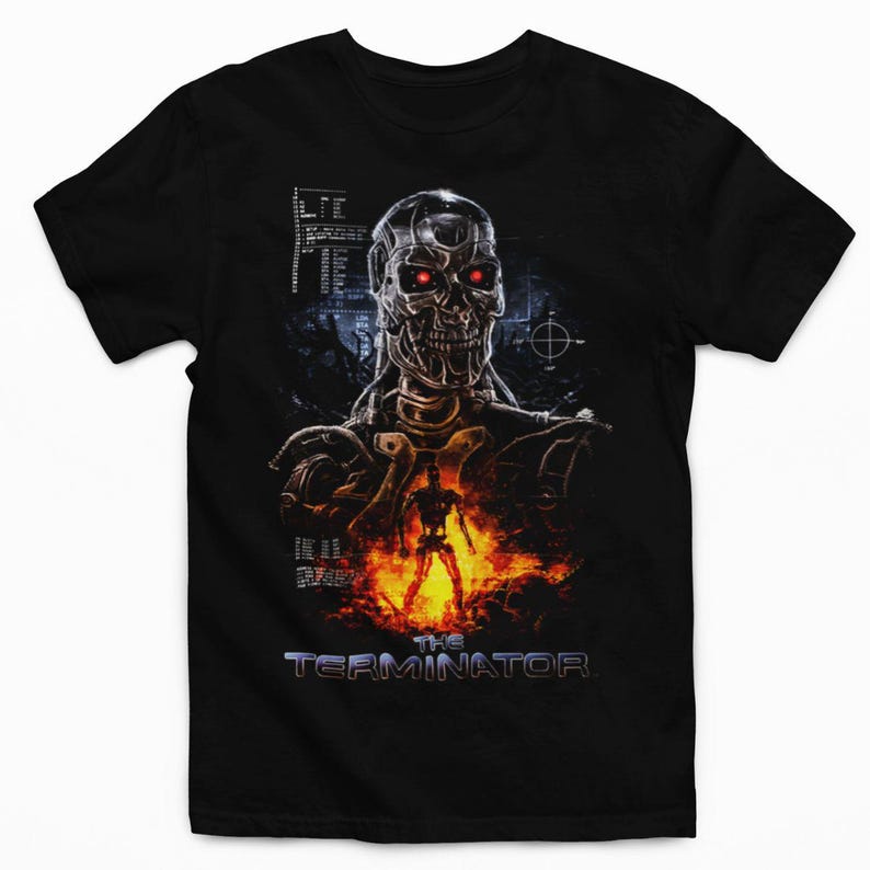 May include: A black short-sleeve t-shirt featuring a graphic print of a metallic cyborg skull with glowing red eyes. Below the skull, a small full-body cyborg figure stands amidst orange flames. The text THE TERMINATOR appears at the bottom.