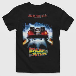 Puede incluir: Una camiseta negra con un gr&aacute;fico de un coche deportivo con una matr&iacute;cula que dice OUTATIME, rodeado de rayos azules y llamas. Sobre el coche, un texto digital rojo dice NOV 05 1955 01:21. Debajo, aparece el texto BACK TO THE FUTURE.