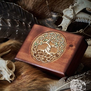May include: A wooden box with a Celtic knot design featuring a tree of life. The box is stained a rich brown color and has a smooth, polished finish.