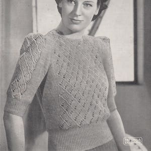 Puede incluir: Un patrón de tejido de punto vintage que presenta a una mujer con un suéter delicado de punto abierto con cuello redondo y mangas cortas. El patrón se titula "Patons Beehive Fingering, 2-Ply" y está numerado como "965".
