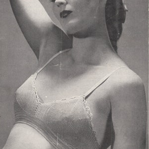 May include: A black and white photograph of a woman wearing a crocheted bra. The bra is made with a delicate, openwork stitch. The text on the image reads "BESTWAY LEAFLET 889 3d CROCHET BRASSIERE Two 20-gramme Balls of Coats Mercer-Crochet".