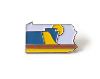 Könnte beinhalten: Eine silberne Emaille-Anstecknadel in Form des Bundesstaates Pennsylvania mit einem stilisierten Sonnenuntergangsdesign in Gelb, Orange, Blau und Lila.