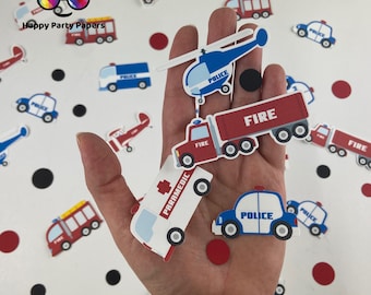 Op de afbeelding: Een verscheidenheid aan kleurrijke papieren uitsnijdingen van hulpdiensten, waaronder brandweerwagens, politieauto's, ambulances en een helikopter. De uitsnijdingen zijn verspreid over een wit oppervlak, sommige worden in een hand gehouden.