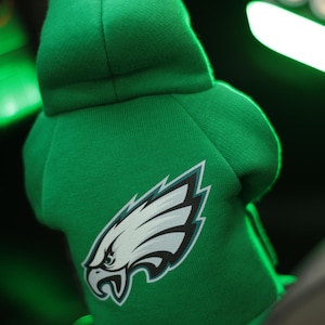 May include: Green hooded sweatshirt with a white and green Philadelphia Eagles logo.