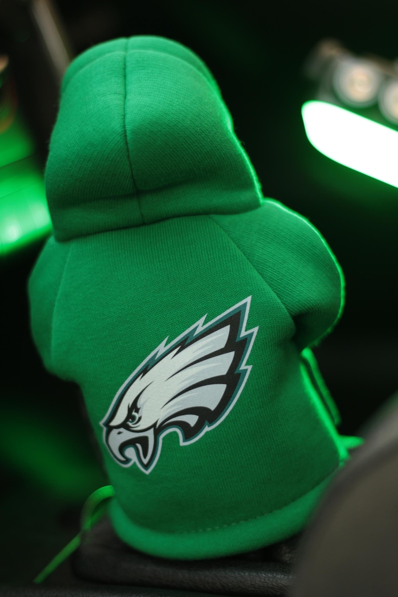 May include: Green hooded sweatshirt with a white and green Philadelphia Eagles logo.