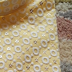 May include: A yellow kurta with white embroidery and a white collar. The kurta has a label that says "I Elegant Wear".