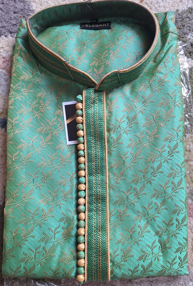 May include: A mint green kurta shirt with a floral pattern and gold trim. The shirt has a mandarin collar and a decorative buttoned placket. The brand name "L.ELEGANT" is visible on the collar.
