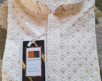 May include: White cotton shirt with a delicate embroidered pattern. The shirt has a mandarin collar and a button-up closure. The shirt is labeled "I. ELEGANT WEAR" and "Wear To Impress".