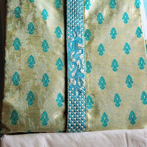 Op de afbeelding: Een lichtgroene kurta met een blauwe en witte geborduurde rand. De kurta heeft een mandarijnkraag en een knoopsluiting.