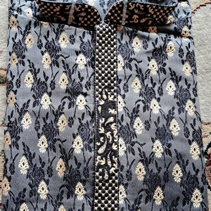 Op de afbeelding: Een grijze en zwarte kurta met een gouden geborduurd ontwerp. De kurta heeft een mandarijnkraag en een knoopsluiting.