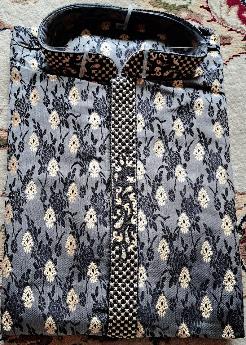 Op de afbeelding: Een grijze en zwarte kurta met een gouden geborduurd ontwerp. De kurta heeft een mandarijnkraag en een knoopsluiting.