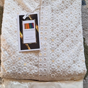 Puede incluir: Kurta blanco bordado con un shalwar blanco. El kurta tiene un cuello mandar&iacute;n y un patr&oacute;n decorativo de peque&ntilde;os c&iacute;rculos y cruces. La etiqueta en el kurta dice "I Elegant Wear" e incluye un n&uacute;mero de tel&eacute;fono: "Whatsapp 3479876608".