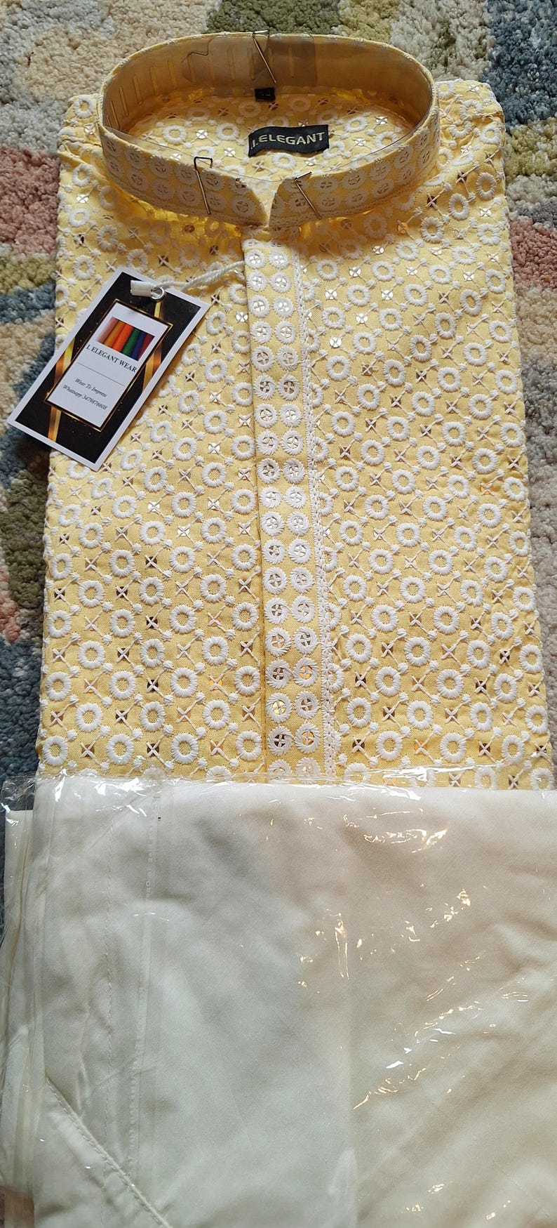May include: A yellow kurta with white embroidery and a white collar. The kurta has a label that says "I Elegant Wear".