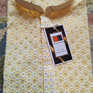 May include: A yellow embroidered shirt with a white collar and a white tag that says "I Elegant Wear" with the text "Wear To Impress" and a WhatsApp number.