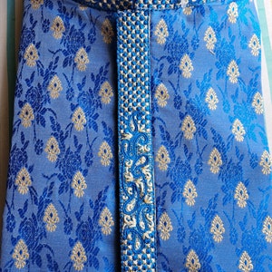 Op de afbeelding: Een blauwe kurta met een wit en gouden geborduurd ontwerp. De kurta heeft een mandarijnkraag en een knoopsluiting.