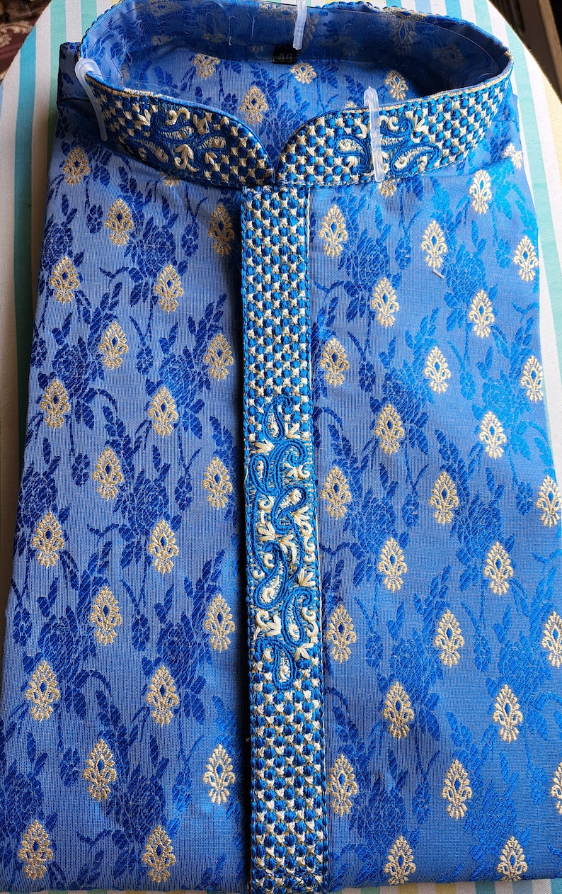 Op de afbeelding: Een blauwe kurta met een wit en gouden geborduurd ontwerp. De kurta heeft een mandarijnkraag en een knoopsluiting.