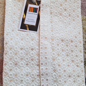Puede incluir: Una kurta de algod&oacute;n blanco con bordados dorados. La kurta tiene un cuello mandar&iacute;n y un cierre de bot&oacute;n. La tela es ligera y transpirable, lo que la hace perfecta para el clima c&aacute;lido. La kurta es una prenda tradicional india que a menudo se usa para ocasiones especiales.