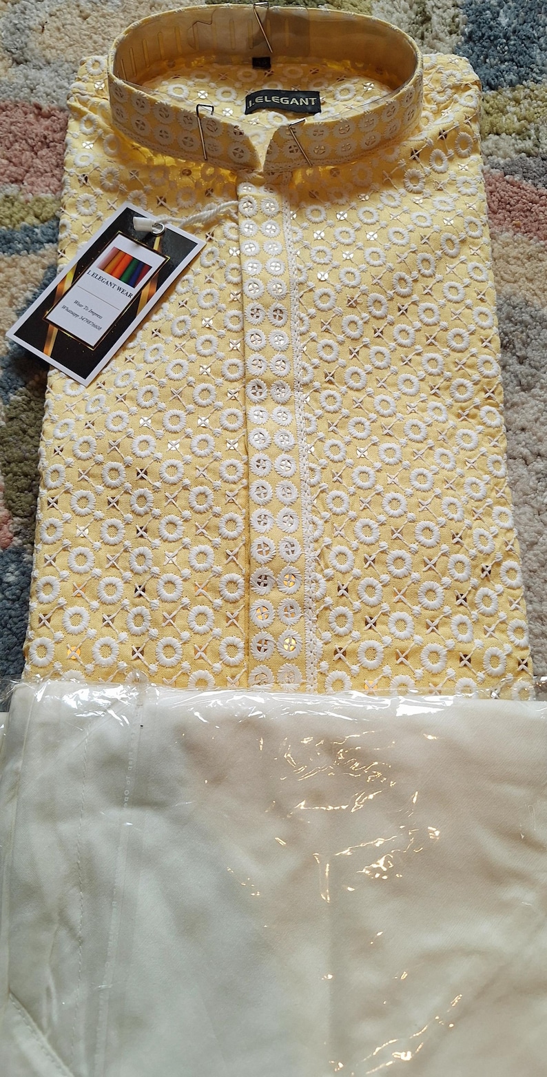Puede incluir: Una kurta amarilla con bordados y lentejuelas blancas. La kurta tiene un cuello mandar&iacute;n y un cierre de bot&oacute;n. La kurta est&aacute; empaquetada en una bolsa de pl&aacute;stico transparente con una etiqueta blanca que dice "I Elegant Wear".