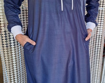 Könnte beinhalten: Ein marineblaues Langarmhemd mit einem weißen Reißverschluss und weißen Besätzen. Das Hemd hat zwei Taschen und einen weißen Streifen auf der Schulter.