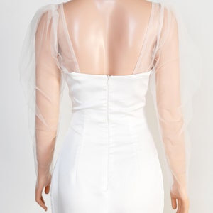May include: White bridal separates with a fitted skirt and a sweetheart neckline. The top features sheer, puffed sleeves.
