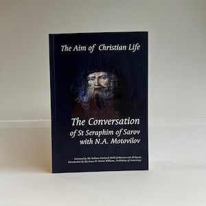 Può includere: Copertina di un libro con il ritratto di un uomo con una lunga barba e un cappello nero. Il titolo è "The Conversation of St Seraphim of Sarov with N.A. Motovilov".
