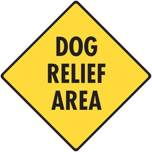 May include: A yellow diamond-shaped sign with black text that reads "DOG RELIEF AREA".
