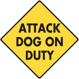 Op de afbeelding: Een geel, ruitvormig waarschuwingsbord met zwarte tekst die "ATTACK DOG ON DUTY" luidt.