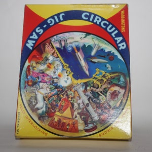 May include: Vintage Waddington's Circular Jigsaw Puzzle box. The box is yellow, red, and blue with the words "JIG-SAW CIRCULAR" in a blue arc. The puzzle image features a surreal collage with rockets, clocks, and other objects. The box reads "FULLY INTERLOCKING" and "PIECES".