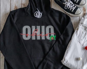 May include: Black hooded sweatshirt with the word "OHIO" in white letters with a red outline and a green and brown buckeye nut graphic.