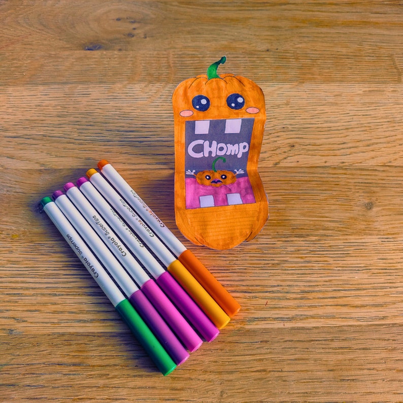 A child’s hand holding the pumpkin puppet, displaying its cheerful expression and bright orange color, perfect for Halloween fun.