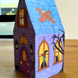 Completed printable 3D haunted house showcasing how the right side looks upclose . The model is vividly colored and features detailed Halloween elements including a witch, black cat and a large black tree.
