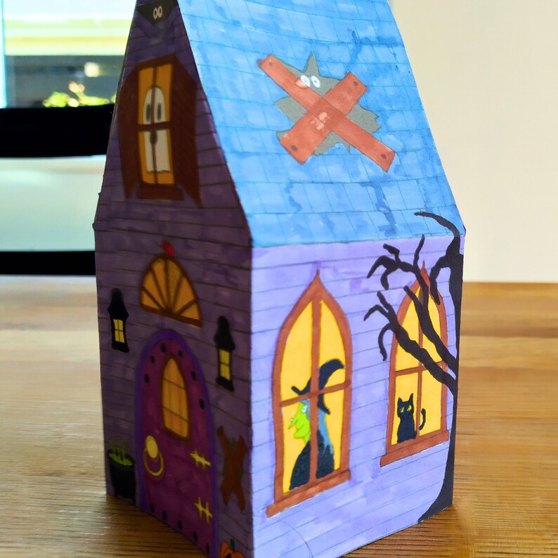 Completed printable 3D haunted house showcasing how the right side looks upclose . The model is vividly colored and features detailed Halloween elements including a witch, black cat and a large black tree.