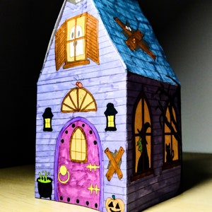 Completed printable 3D haunted house showcasing how the front looks upclose as well as the right side . The model is vividly colored and features detailed Halloween elements including a pumpkin, ghost, spider, and a large front door.
