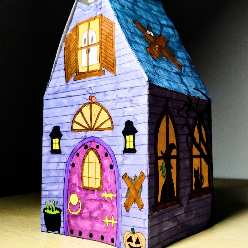 Completed printable 3D haunted house showcasing how the front looks upclose as well as the right side . The model is vividly colored and features detailed Halloween elements including a pumpkin, ghost, spider, and a large front door.