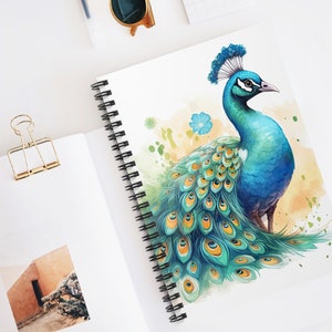 May include: A spiral-bound notebook featuring a watercolor illustration of a peacock. The peacock is depicted with vibrant blue, green, and yellow feathers. The notebook has a white cover and black spiral binding. The background is white.