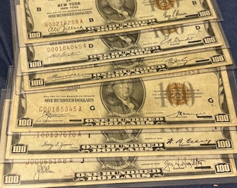 May include: A collection of vintage $100 US Federal Reserve notes, each in a clear protective sleeve. The notes display a portrait of Benjamin Franklin and the text "ONE HUNDRED DOLLARS". The bills are from various Federal Reserve Banks.