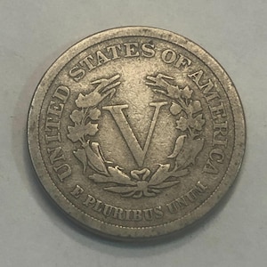 May include: A silver United States five-cent coin with the inscription "UNITED STATES OF AMERICA" and "E PLURIBUS UNUM" around a wreath with the Roman numeral "V" in the center.