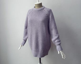 May include: A lilac-coloured, oversized jumper with a crew neck and long sleeves. The jumper features a textured knit pattern and ribbed cuffs and hem. The garment is displayed on a white mannequin against a plain white background.