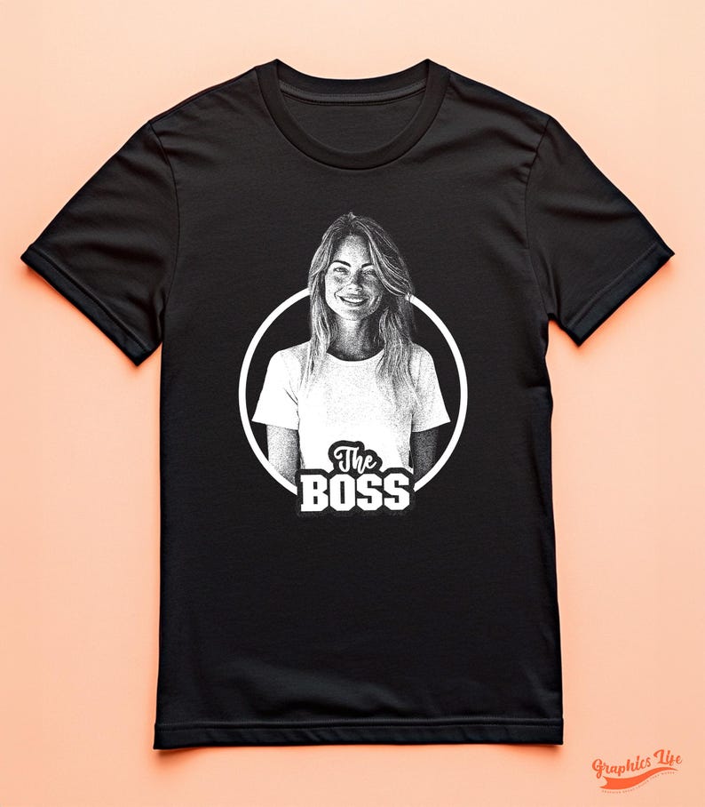 May include: Black t-shirt with a white circle graphic featuring a woman's portrait and the text "The Boss".