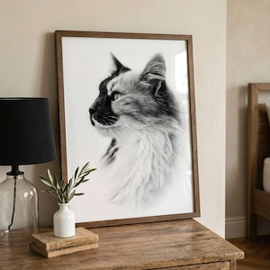 May include: A rectangular wall art print featuring a black and white profile portrait of a long-haired cat. The print is encased in a thin, medium-toned wooden frame, showcasing the cat's detailed fur texture and focused gaze in high contrast.