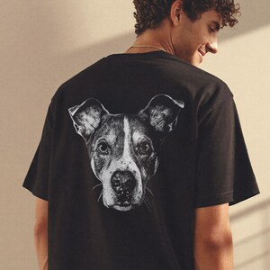 Puede incluir: Camiseta negra con un gr&aacute;fico en blanco y negro del rostro de un perro en la espalda. El perro tiene un patr&oacute;n blanco y negro. La camiseta est&aacute; hecha de un material suave.
