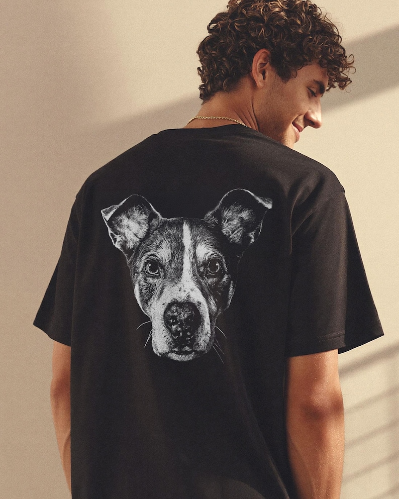Puede incluir: Camiseta negra con un gr&aacute;fico en blanco y negro del rostro de un perro en la espalda. El perro tiene un patr&oacute;n blanco y negro. La camiseta est&aacute; hecha de un material suave.