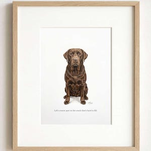 A pastel portrait of a chocolate-brown dog in a light oak frame with a wide white mount, photographed straight on against a plain pale wall.