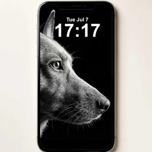 May include: A smartphone displaying a black and white wallpaper of a dog in profile on its screen. The screen shows the text Tue Jul 7 and the time 17:17 in white font. The device has a silver frame and a black border around the display area.