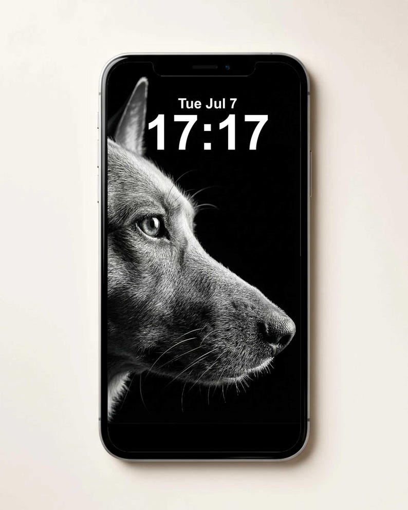 May include: A smartphone displaying a black and white wallpaper of a dog in profile on its screen. The screen shows the text Tue Jul 7 and the time 17:17 in white font. The device has a silver frame and a black border around the display area.