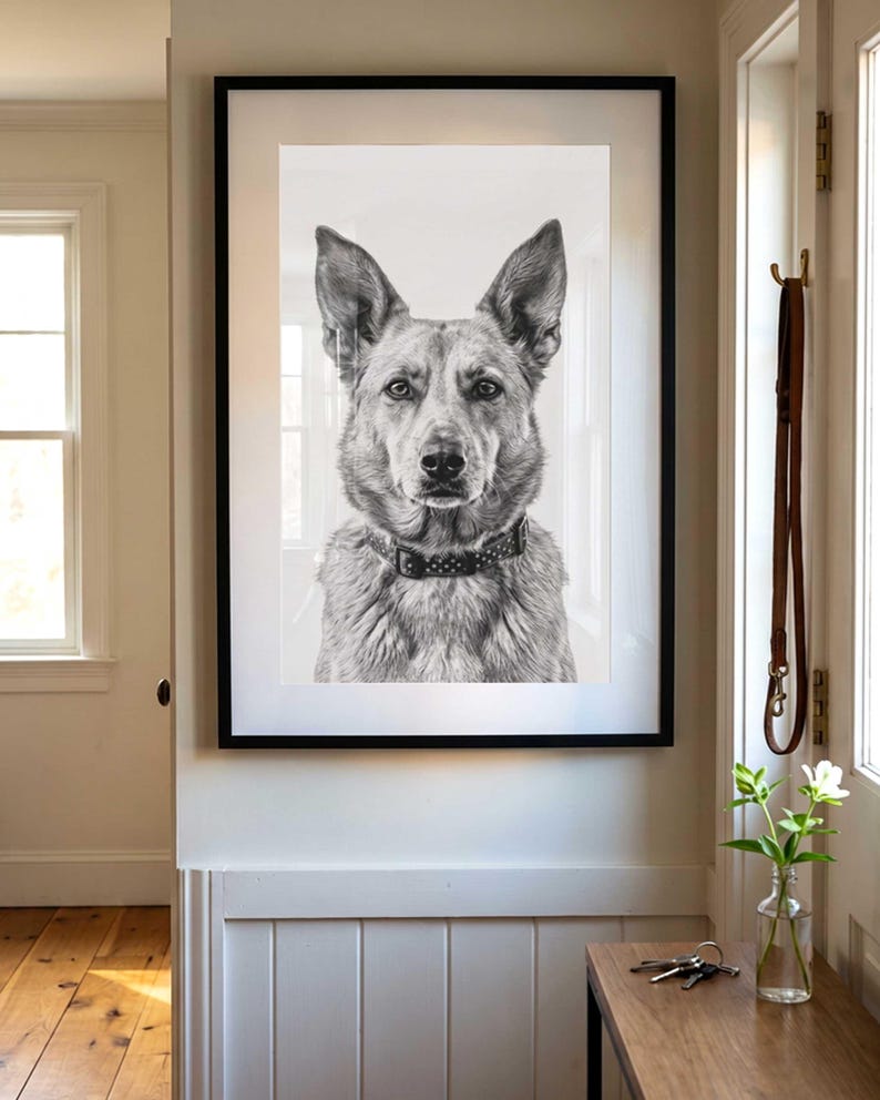 May include: A black and white portrait of a dog with pointed ears and a studded collar, presented in a rectangular frame with a thin black border. The artwork captures the detailed facial features and fur texture of the animal in a realistic style.